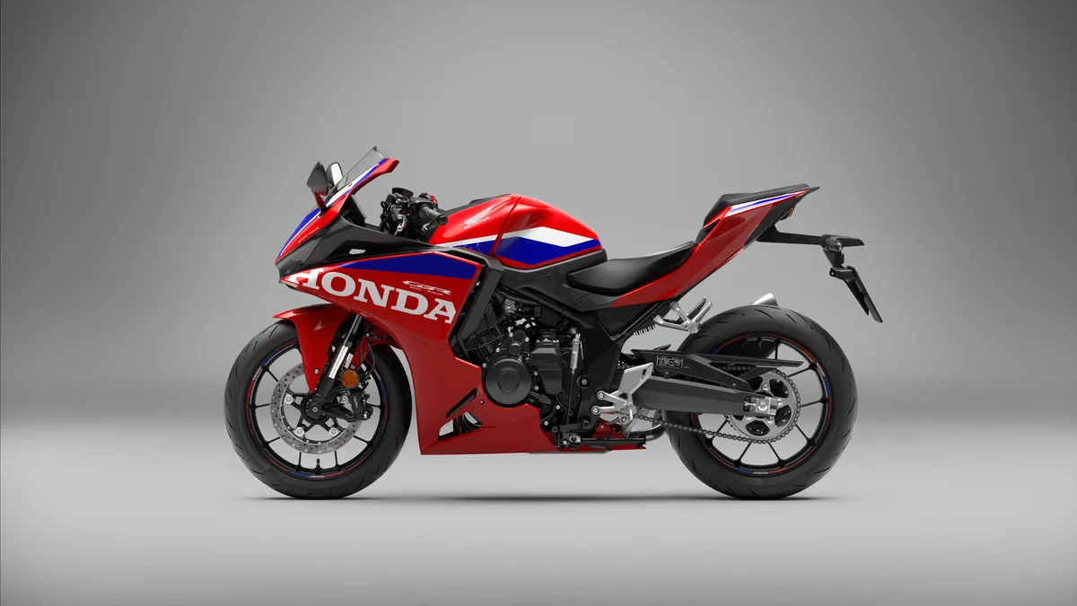Honda CBR500R FOUR rouge, blanche et bleue vue de trois quarts arrière, en studio