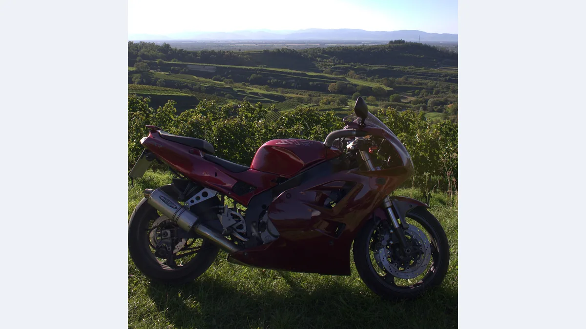 Kawasaki ZXR400 de 1992 rouge bordeaux garée au bord d'un vignoble