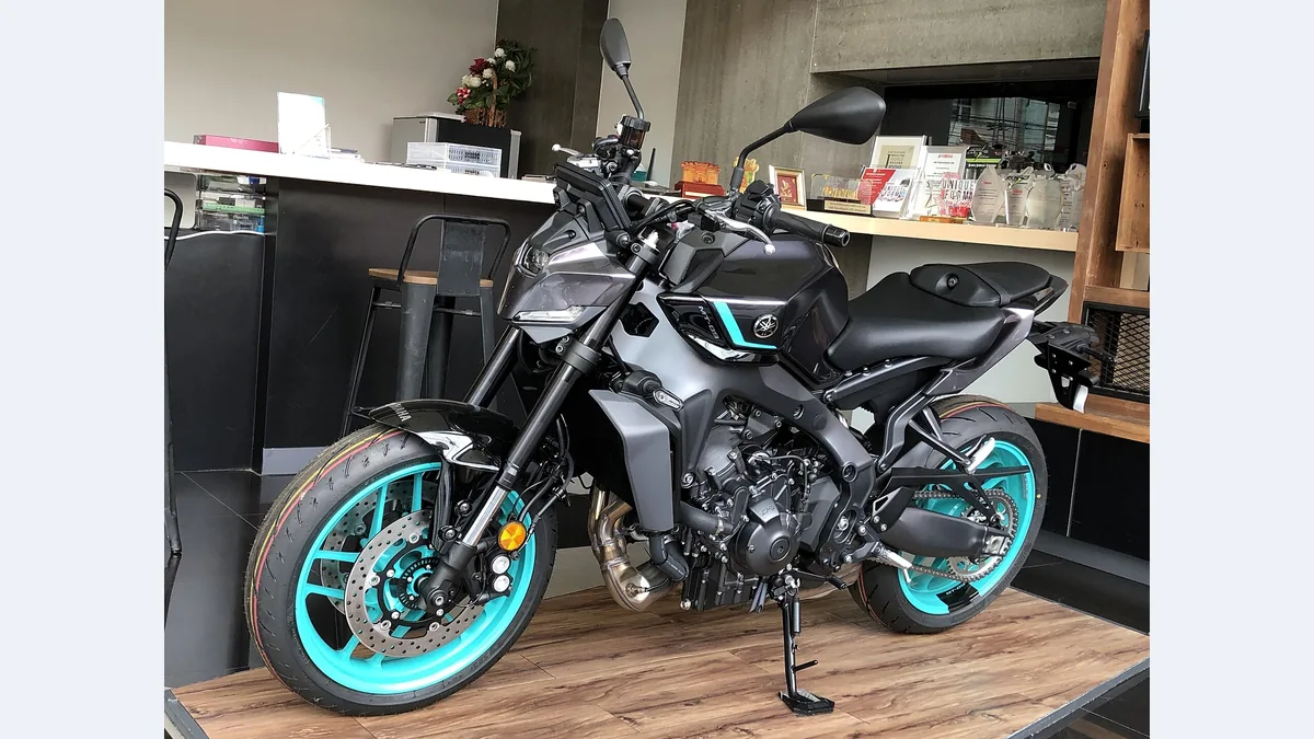 Yamaha MT-09 de la génération actuelle, grise avec jantes turquoise, exposée en concession